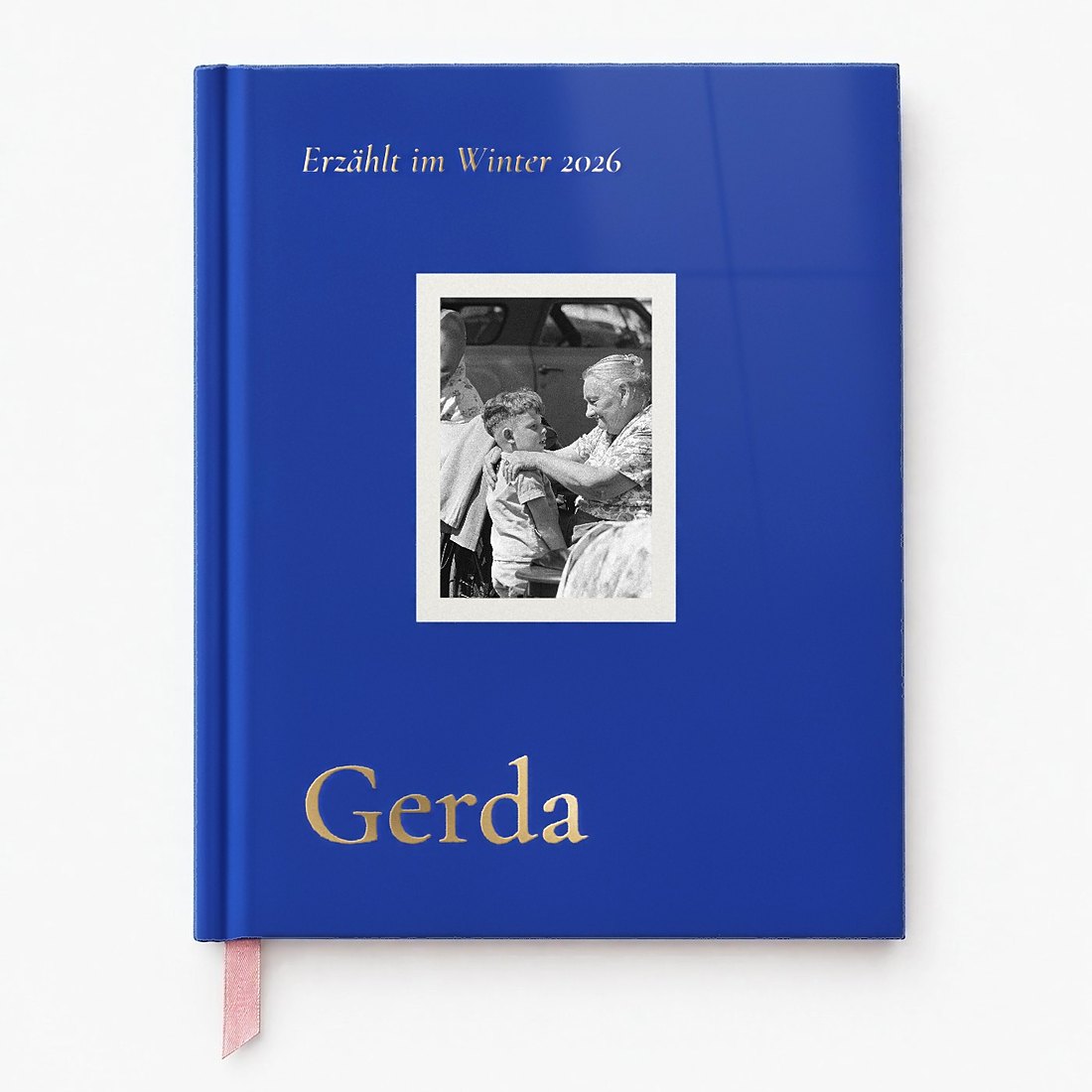 Gebundenes Buch mit glänzendem Umschlag in Tinte, Foto im weißen Rahmen und dem Namen Gerda in Goldlack